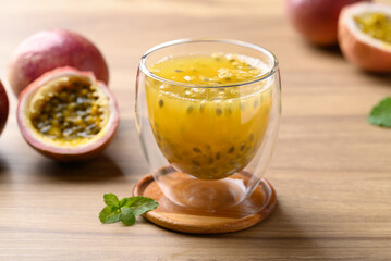 Glass of passion fruit juice with fresh passion fruit on wooden background, Healthy drink