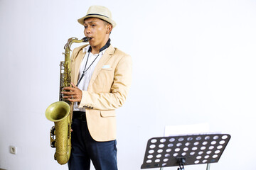 Young Asian Man Jazz Musician Playing The Saxophone While Standing