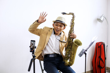 Naklejka premium Cheerful Young Musician Male As a Video Blogger Saying Hello While Recording Video