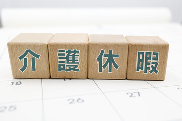 介護休暇と書かれた木のブロックがカレンダーの上に置かれている