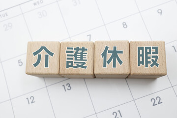 介護休暇と書かれた木のブロックがカレンダーの上に置かれている