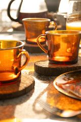 breakfast table on a sunny day outside with close-up of cold coffee cups and rustic wooden pads