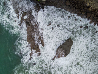 Epic Aerial Shot of Crashing Waves, Rocky Reef, and Coastal Cliffs – Top-Down View