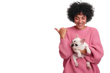 happy woman holding french bulldog puppy and pointing left on black