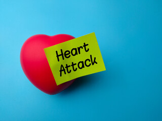 Closeup red heart shape with the word Heart Attack on a blue background