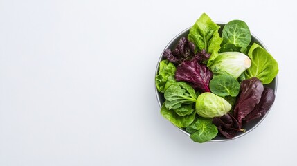 Fresh mixed salad leaves in a bowl on a white background, showcasing vibrant green and purple colors.