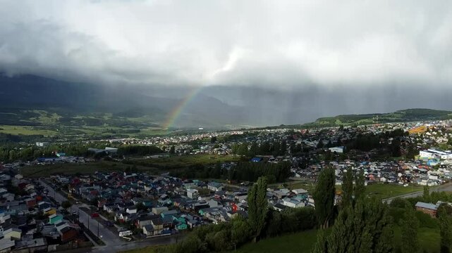 toma aerea de la ciudad de Coyhaique Patagonia Chile, de fondo se ve un arcoiris. 