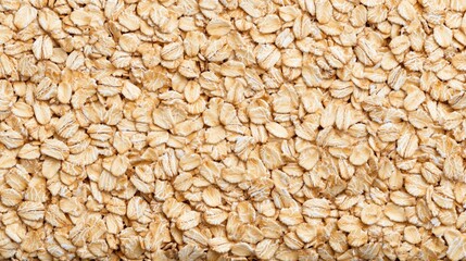 Close-up view of uncooked rolled oats, showcasing a textured and natural grain surface commonly used for breakfast and baking.
