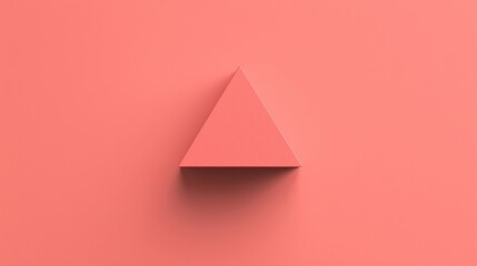 Fototapeta premium A pink triangular prism sits centered on a matching pink background, creating a minimalist, geometric composition.