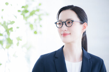 スーツを着て振り返える女性　左にコピースペースありのクローズアップ