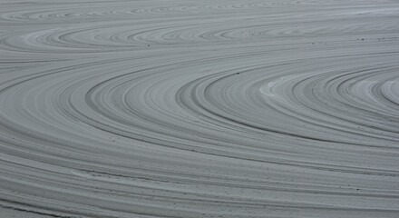 Fototapeta premium Abstract pattern of curved lines on a grey surface creating a textured background with flowing, wave-like shapes and subtle variations in tone and depth