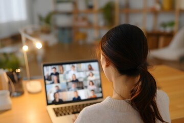 Young Woman Attending Online Video Conference on Laptop from Cozy Home Office in Warm Lighting