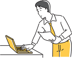 書類を片手にパソコン画面を見る男性社員