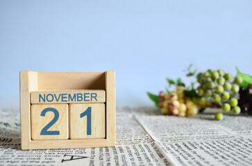 November 21, Calendar cover design with number cube with fruit on newspaper fabric and blue background.	