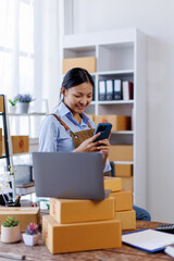 Portrait of Asian female small businesses SME entrepreneur usephone working at home, online...