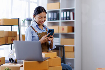 Portrait of Asian female small businesses SME entrepreneur usephone working at home, online...