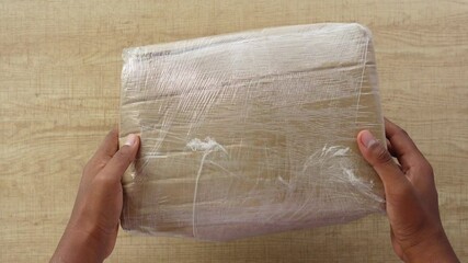 Unboxing a well-wrapped package at home