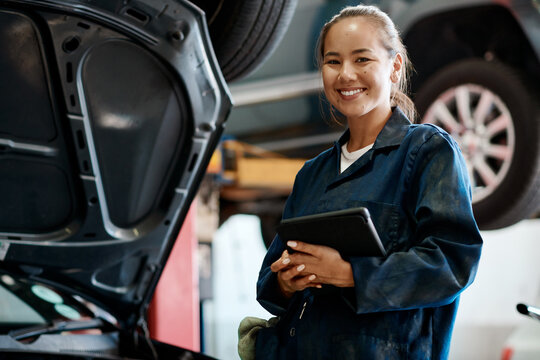 Tablet, portrait and woman in workshop with car service, maintenance or online motor insurance. Tech, engine and female mechanic in garage on digital app for inspection, repair and quality assurance