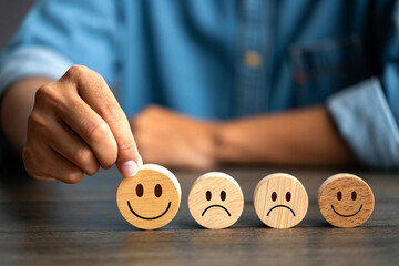 Hand Selecting a Happy Face Block Among Emotional Choices