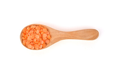 Red lentils and wood spoon isolated on white background