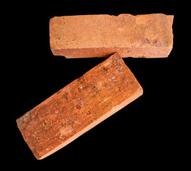 Side view of two old red or orange bricks isolated on black background with clipping path