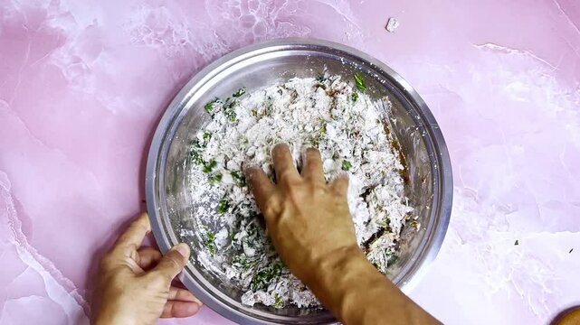 Dough plus herbs mix in shiny steel container