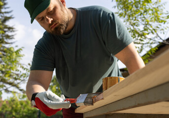 Young man painting an old wooden table.