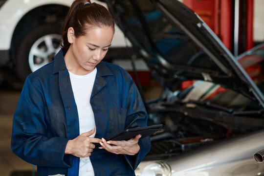 Tablet, inspection and woman in workshop with car service, maintenance or online motor insurance. Tech, engine and female mechanic in garage on digital app for checklist, repair and quality assurance
