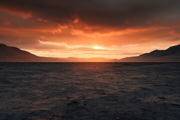 Obraz premium Dramatic Sunset over a Desolate Flat Landscape with Distant Mountains