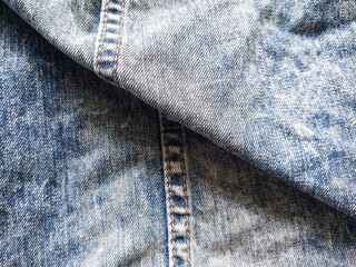 Texture of classic blue jeans denim fabric with seam. Seam and stitching background for vintage...