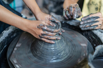 Close-up of hands shaping clay on a spinning pottery wheel.