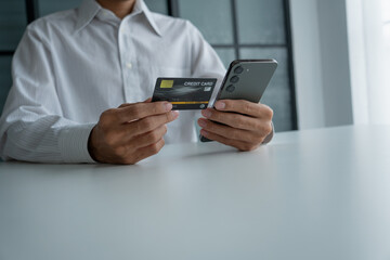 Man holding credit card and phone to pay online
