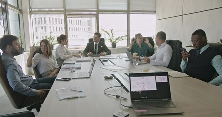 A diverse team of business professionals collaborates on a project during a productive meeting in a modern office. - Powered by Adobe