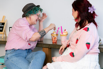 Lesbian couple share milkshake while chatting on date