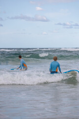 Beginner Surfers Prepare to Paddle - Teenage Boys learn to surf