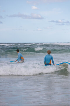Beginner Surfers Prepare to Paddle - Teenage Boys learn to surf