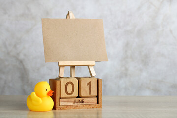 Wooden calendar showing june 1st with blank canvas and rubber duck