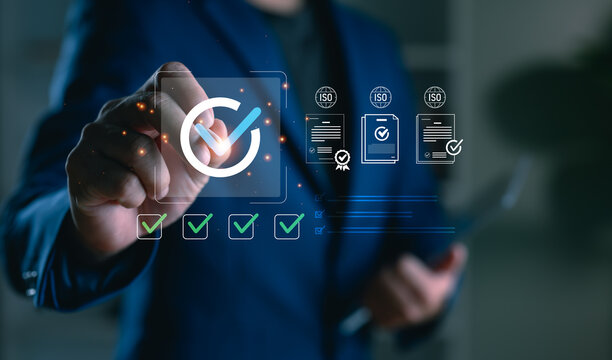 A businessman interacting with digital checkmarks and ISO document icons, representing quality control, standard certification workflow, compliance process, and international audit readiness.