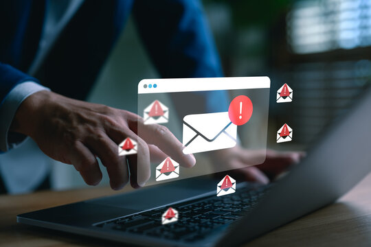 A businessman using a laptop with floating email alert icons, symbolizing phishing attacks, spam threats, and cybersecurity risks in modern digital communication systems.