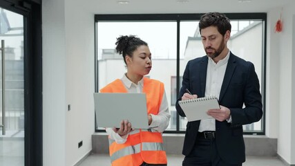 Handsome professional investor and construction engineer discussing a project in a modern building. They are formally dressed and feel confident and focused during a business meeting.