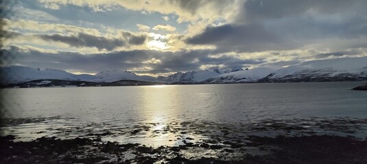 Obraz premium Gorgeous picture of the sunset over the fjords in Tromsø, Norway, during a lovely spring evening.