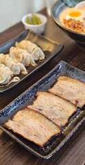 Kanuni pork and Gyoza in black sauce serving with spicy ramen