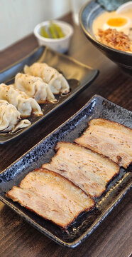 Kanuni pork and Gyoza in black sauce serving with spicy ramen