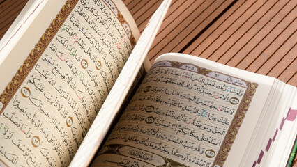 Bandung, Indonesia - 02.11.2025:  Photo of opened Holy Quran with Arabic calligraphy with natural...