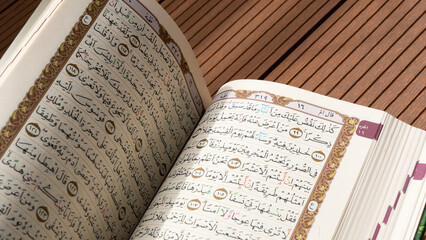 Bandung, Indonesia - 02.11.2025:  Photo of opened Holy Quran with Arabic calligraphy with natural...