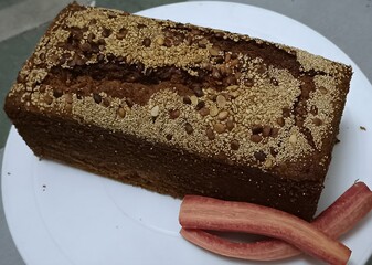 Moist and flavorful homemade carrot cake made with all-purpose flour, topped with a crunchy layer of sesame and mixed seeds, served with fresh carrot sticks. A classic treat with texture.