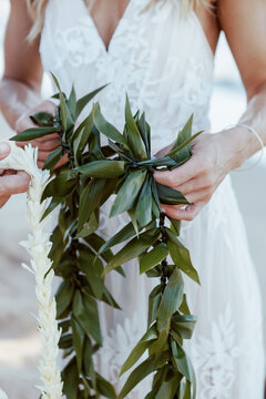 Newlyweds Holding Hawaiian Leis at Beach Elopement