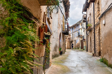 Tourist woman strolling through the narrow and picturesque streets of the medieval village of Rafales, Teruel.