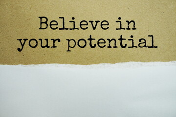 Believe In Your Potentialmessage written on white paper with torn paper background