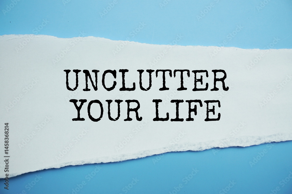 Poster unclutter your life message written on white paper with torn paper background